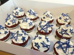 cupcakes decorated with blue and white icing in a box