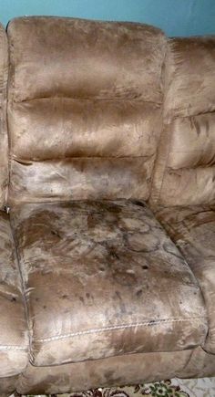 a dirty couch sitting on top of a rug