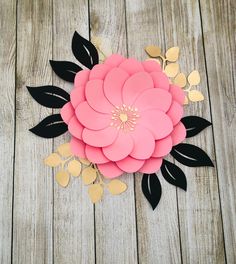 the paper flower is cut out and placed on top of wood planks with gold leaves