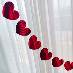 red hearts hanging from the side of a curtain