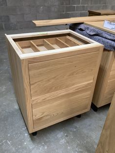 a wooden cabinet with two drawers and a towel on the top shelf next to it