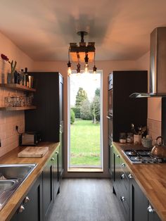 an open kitchen door leading to a lush green field outside the window is lit by lights