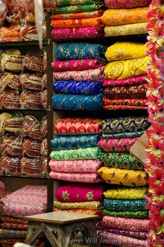 many different colored fabrics on display in a store