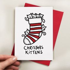 a hand holding up a card with a christmas stocking on the front and bottom