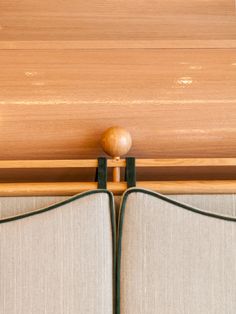 the back of a bed with two pillows and a wooden headboard on top of it