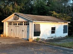 a white garage with two doors and windows