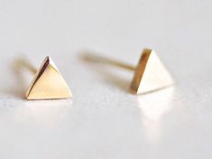 Dainty 14KT Yellow Gold-Plated Triangle Stud Earrings that look great in any ear. They are the perfect little spot of shine or great for the nose, or 2nd and 3rd earlobe piercings. Base Metal: Sterling Silver Plating: 14KT White Gold Push-back closure Triangle diameter: 3mm Geometric Earrings Studs, Minimal Earrings Studs, Minimalist Earring, Triangle Earrings Stud, Minimalist Earrings Studs, Geometric Studs, Triangle Studs, Stud Jewelry, Small Earrings Studs