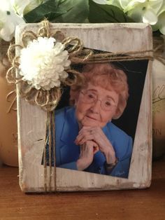 an old woman is sitting in front of some flowers