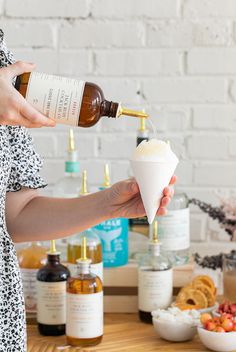 a woman is pouring something into a cup