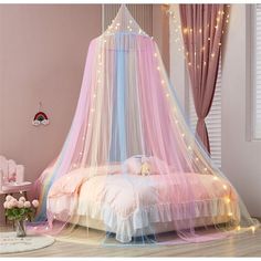 a pink and blue canopy bed with fairy lights on the ceiling in a girls'bedroom