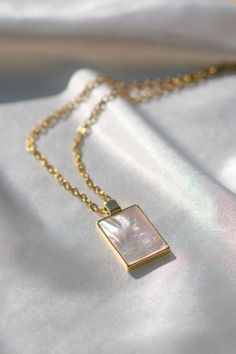 Add a touch of elegance with our Mother-of-Pearl Rectangular Minimalist Pendant Necklace. This stunning piece features a dainty rectangular mother-of-pearl pendant on a delicate gold chain, reflecting light beautifully for a sophisticated look. Perfect for those who love minimalist jewelry with a hint of luxury.

Features:

- Mother-of-Pearl Pendant: Rectangular and reflective, offering timeless elegance.

- Dainty Gold Chain: Lightweight and stylish, perfect for layering or wearing alone.
- Minimalist Design: Ideal for those who appreciate simple yet luxurious accessories.

Whether as a thoughtful gift or a personal treat, this necklace captures the beauty of minimalist design with a luxurious twist. Elegant Rectangular Necklace With Delicate Chain, Elegant White Necklace With Rectangular Pendant, Elegant Rectangular Pendant Necklace For Her, Elegant White Rectangular Pendant Necklace, Elegant Rectangular Everyday Necklaces, Elegant Everyday Rectangular Necklaces, Rectangular White Jewelry With Pearl Drop, Elegant Rectangular Pearl Pendant Necklace, Gold Necklaces With Rectangular Stone