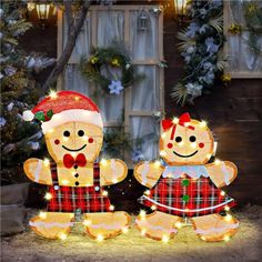 two lighted gingerbreads sitting next to each other