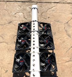 a metal pole with four fans attached to it