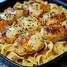 a pan filled with chicken and noodles covered in sauce