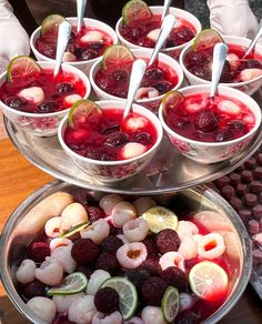 there are many desserts in bowls on the table and one is filled with fruit