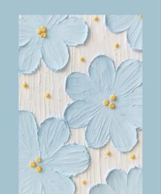 some blue flowers are on a white and light blue background with yellow dots in the middle