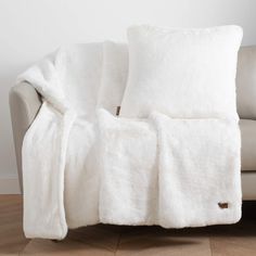 a couch covered in white fluffy blankets with the words macy's written across it