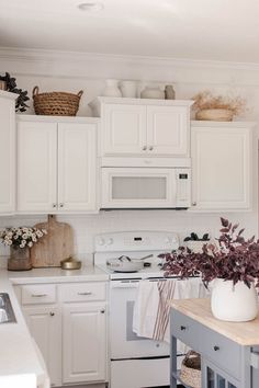 a kitchen with white cabinets and lots of counter space, including a stove top oven