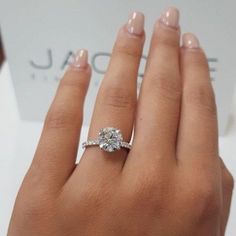 a woman's hand with a diamond ring on it