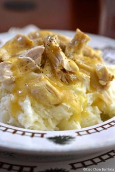 a white plate topped with mashed potatoes covered in gravy