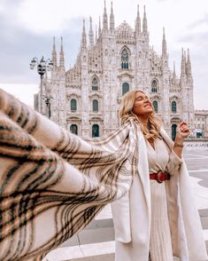 a woman standing in front of a large building