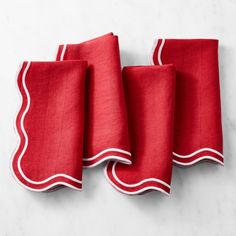 three red napkins with white trim on them