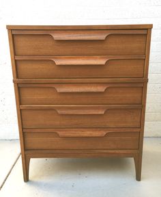 a wooden dresser sitting on top of a white floor