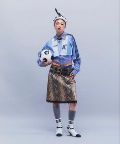 a woman in a skirt holding a soccer ball