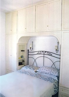 a bedroom with white cabinets and a bed