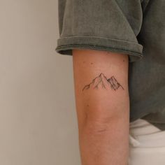 a person with a mountain tattoo on their arm