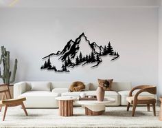 a living room filled with furniture and a mountain wall decal above the couches