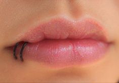 a woman's lips with the lip ring sticking out