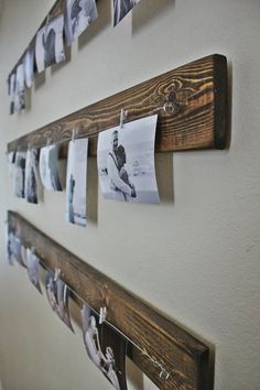 several pictures are hung on the wall with clothes pins