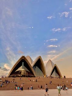 many people are walking around in front of the sydney opera house