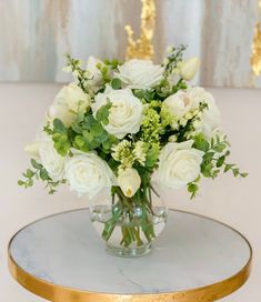 a vase filled with white flowers on top of a table