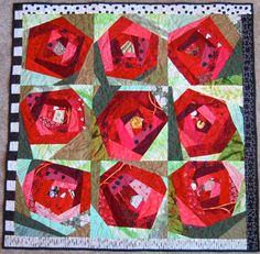 a quilted table topper with red and green designs on it's edges