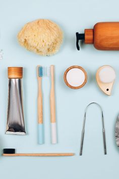 an assortment of dental care items laid out on a light blue surface, including toothbrushes, spoons and other accessories