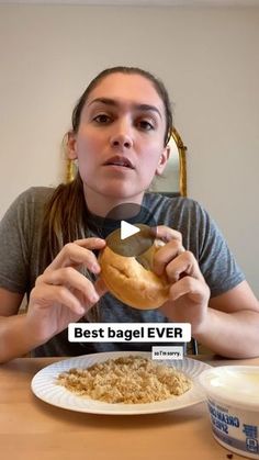 a woman sitting at a table with a bagel in front of her, and the caption best bagel ever