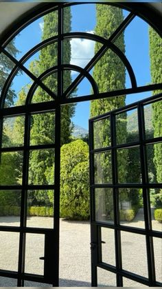 an open door leading to a garden with trees in the background and blue sky above