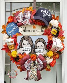 a wreath with two women's faces is hanging on the front door, decorated with fall leaves