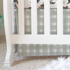 a baby crib with white flowers on the bedding