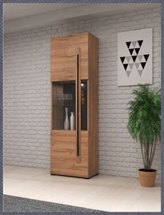 a tall wooden cabinet sitting next to a potted plant