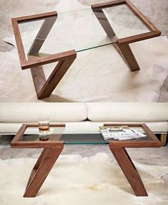 a glass coffee table with wooden legs and an upside down shelf in the middle, sitting on top of a white couch