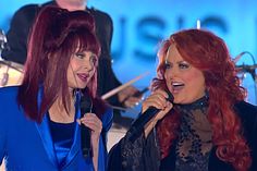 two women with red hair singing into microphones