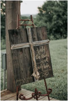 a wooden sign with a cross hanging from it's side