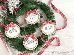 four decorated cookies with the words joy, merry and joy on them are sitting in front of a christmas wreath