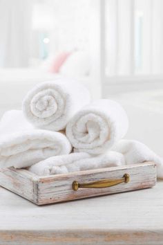 several folded white towels in a wooden tray