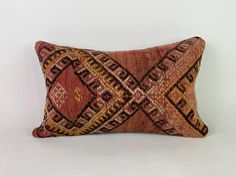 a decorative pillow with an intricate design on the front and back, sitting on a white surface