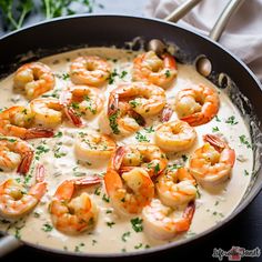 a pan filled with shrimp and sauce on top of a table