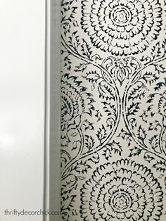 a white and black wallpaper with an intricate design on it's sidewall